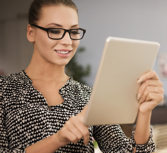 woman-holding-horizontal-tablet-and-tapping-on-it