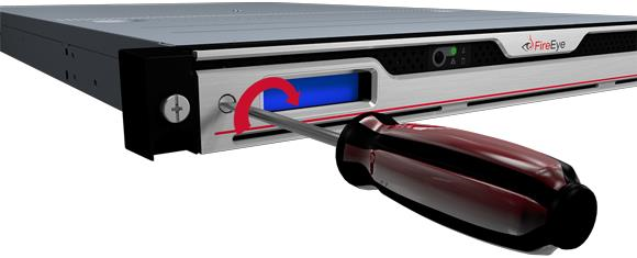 Screwdriver inserted into the left bezel screw of a FireEye appliance front panel, showing a red curved arrow indicating clockwise rotation