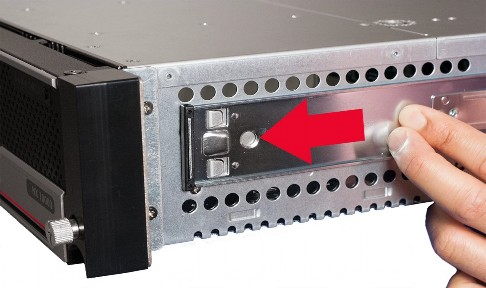 Close-up of the appliance front rail area showing a metal latch with a large red arrow pointing to a round release button and a hand pressing the latch