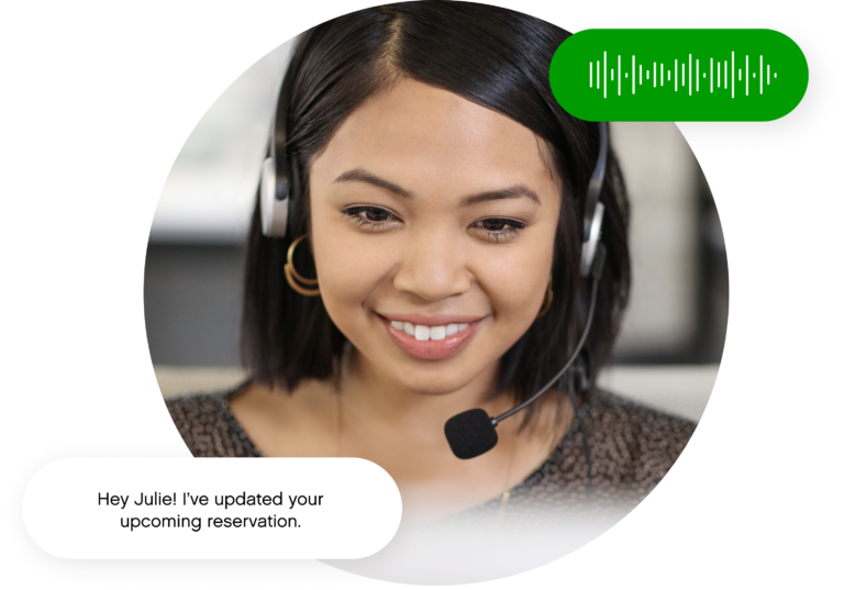 A customer service representative updates a reservation while speaking on a headset.